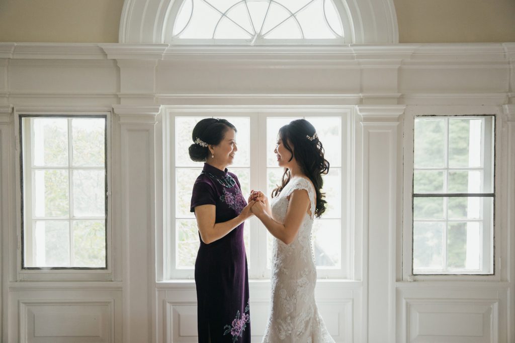 Bride and her mom holding hands during the getting ready at Bourne Mansion wedding