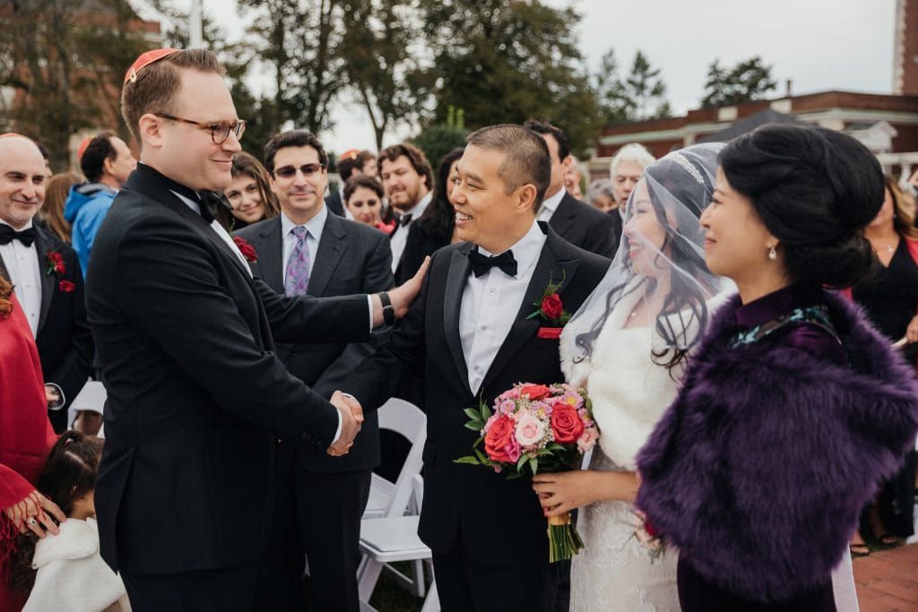 A groom greeting a bride and her parents during a wedding ceremony