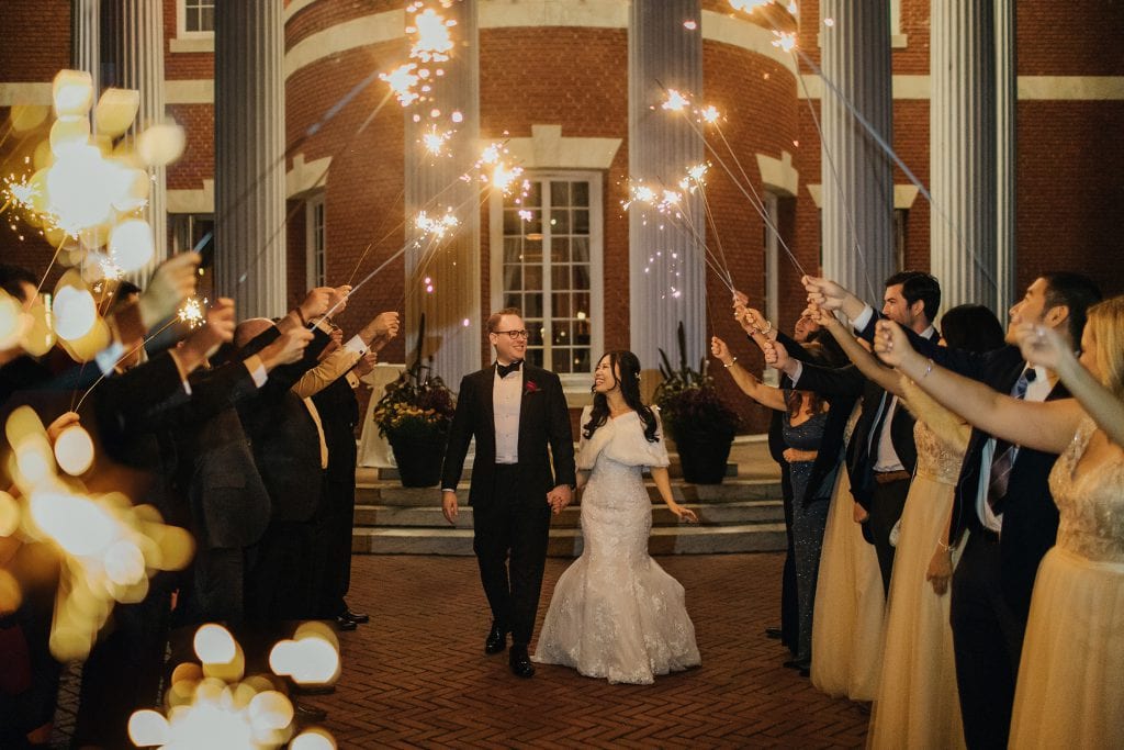 A newly wedded couple exiting their wedding venue end of the night