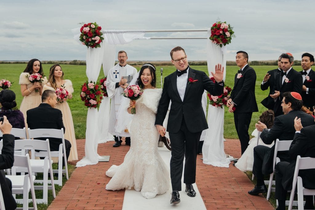 A newly wedded couple exiting their wedding ceremony