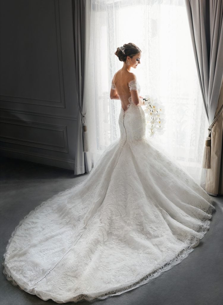 Bride in the gorgeous gown with a train posing in the bridal suite at the St. Regis NYC