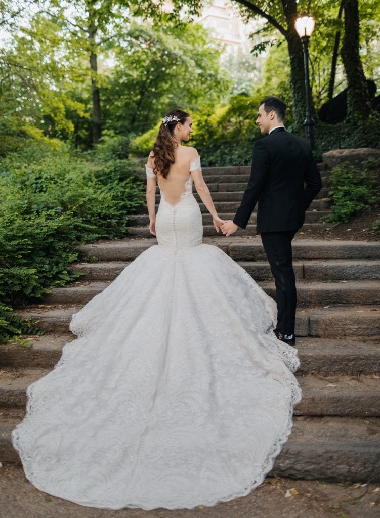 A newly wedded couple walking in Central Park near the Columbus Circle