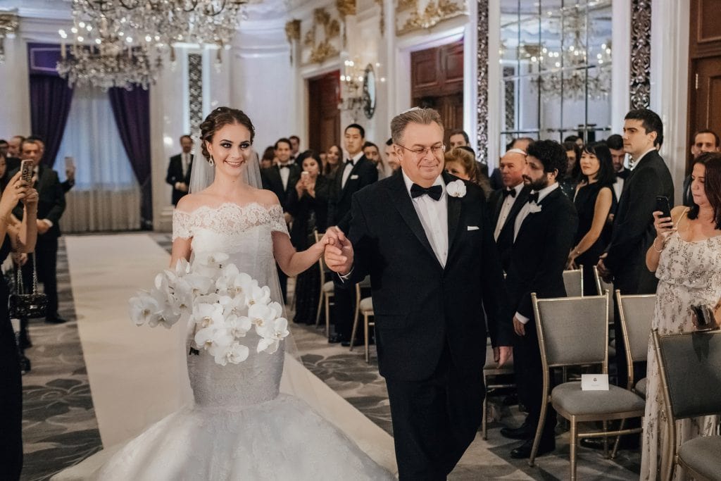 A bride and her father walking during the wedding ceremony at The St. Regis New York