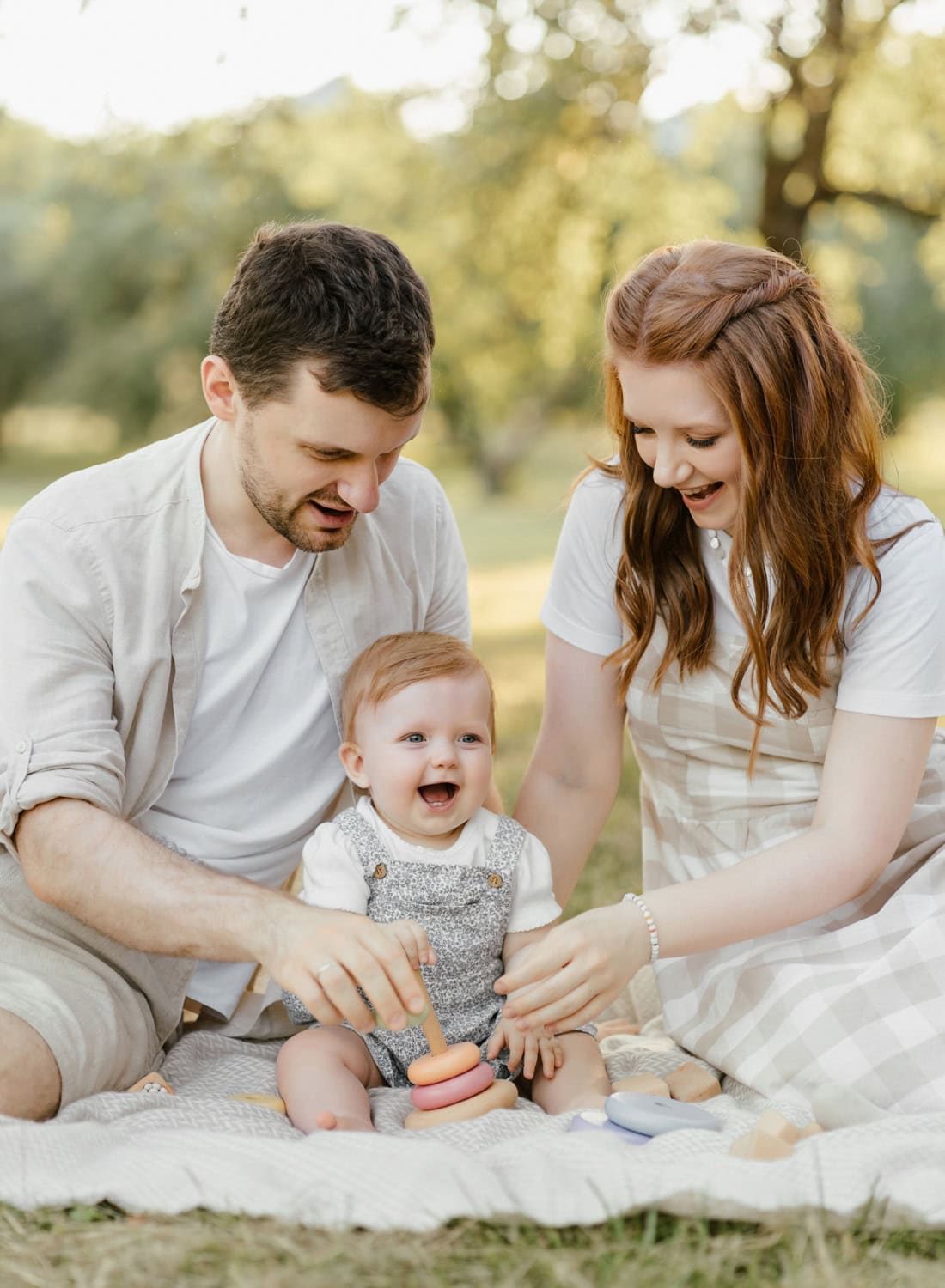 A joyful family enjoying a picnic in a sunlit park, creating lasting memories with their baby during a Westchester family photography session.