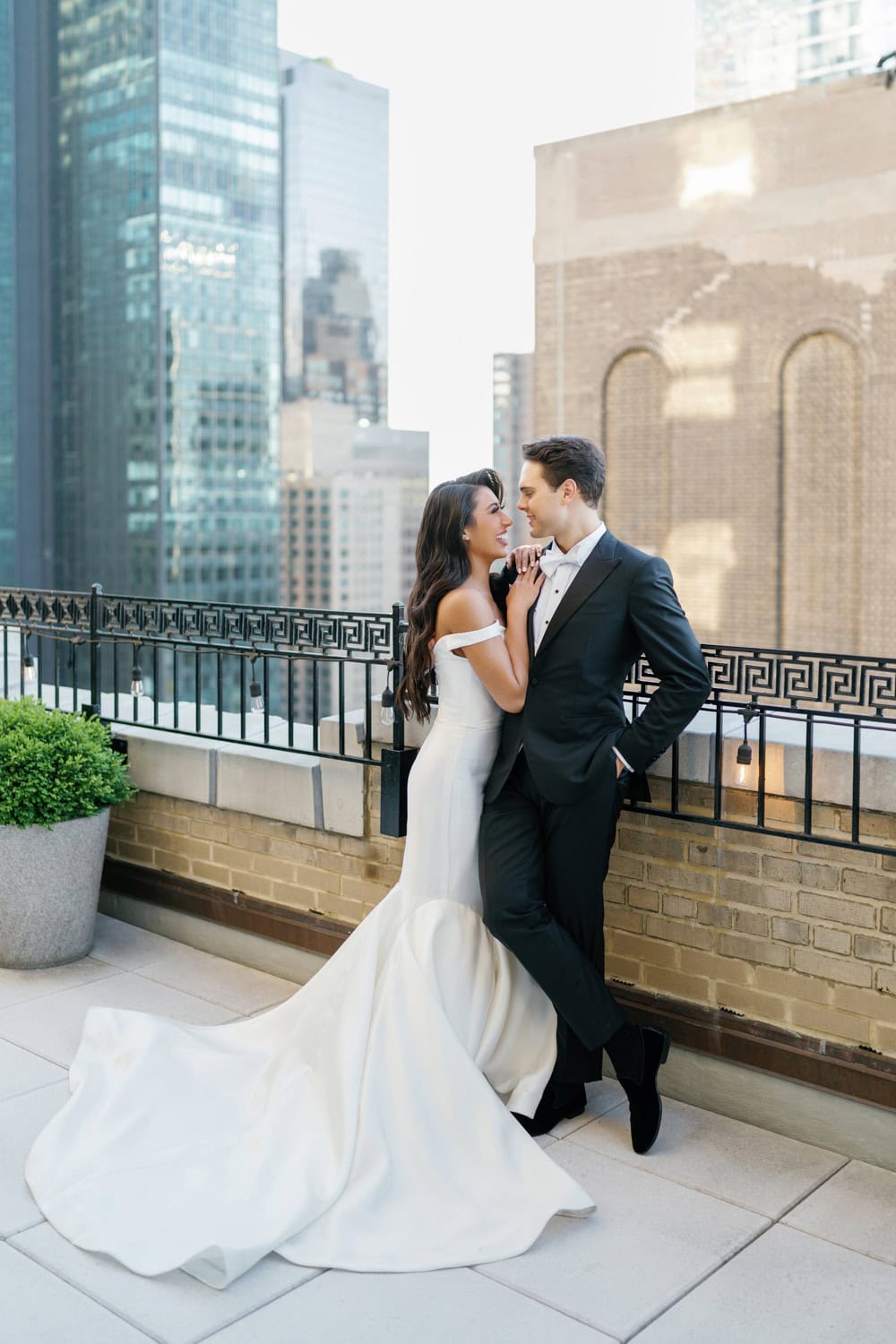 Bride and groom on the terrace of JW Marriott Essex House with a view of the New York City skyline.