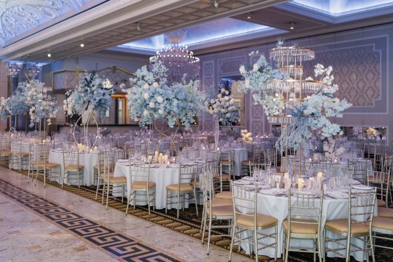 Elegant wedding reception setup at The Venetian in NJ, featuring luxurious floral centerpieces, candlelit tables, and grand chandeliers in the ballroom.