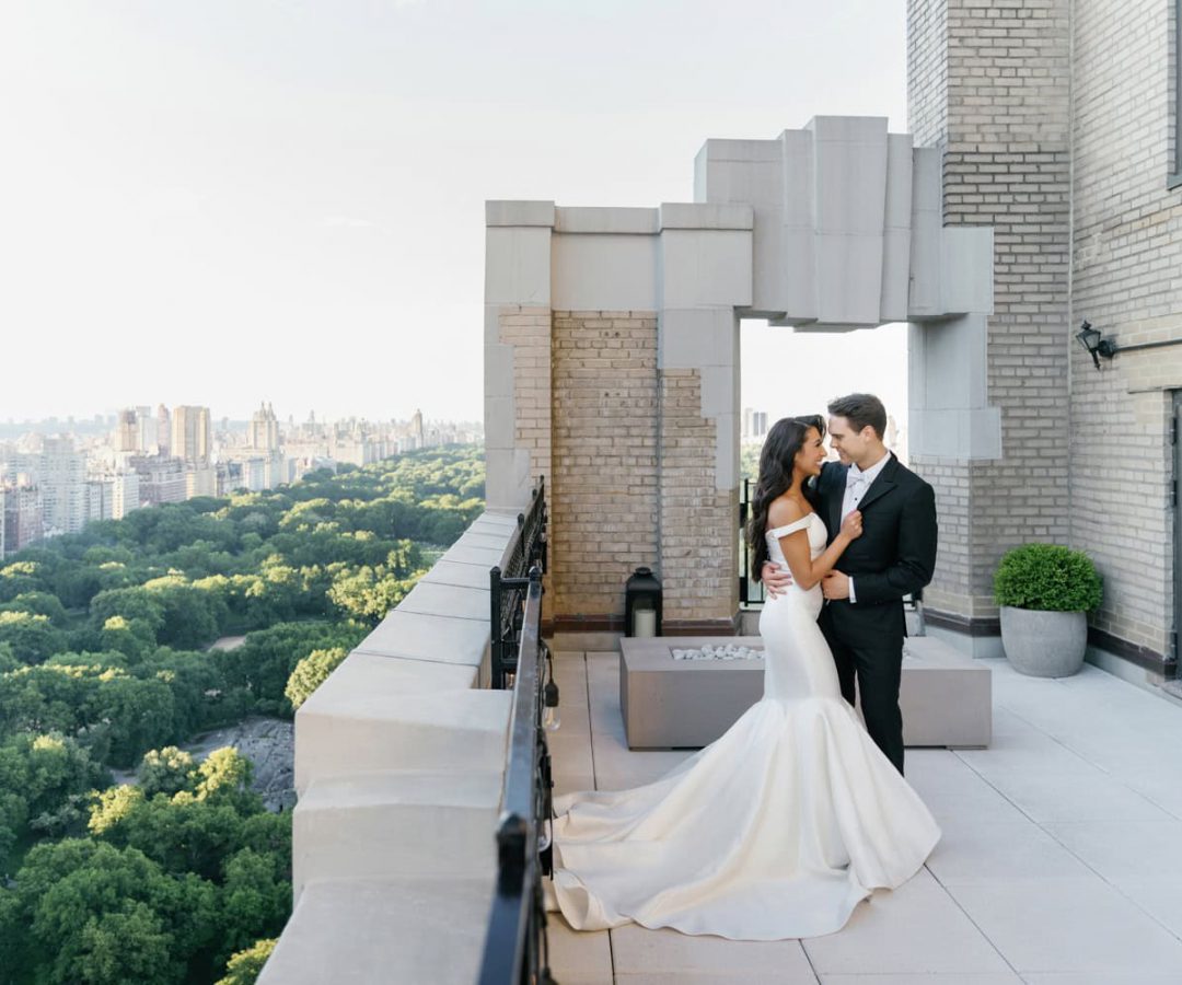 Bride and groom embrace on the private terrace of the JW Marriott Essex House bridal suite, overlooking Central Park with breathtaking city views.