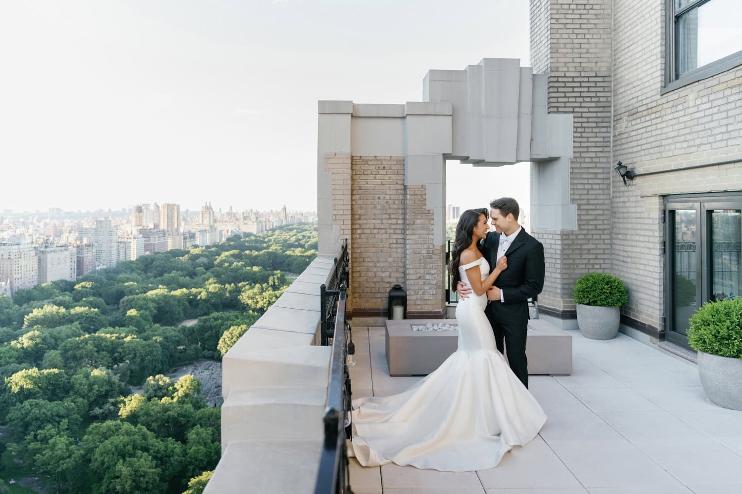 Bride and groom embrace on the private terrace of the JW Marriott Essex House bridal suite, overlooking Central Park with breathtaking city views.