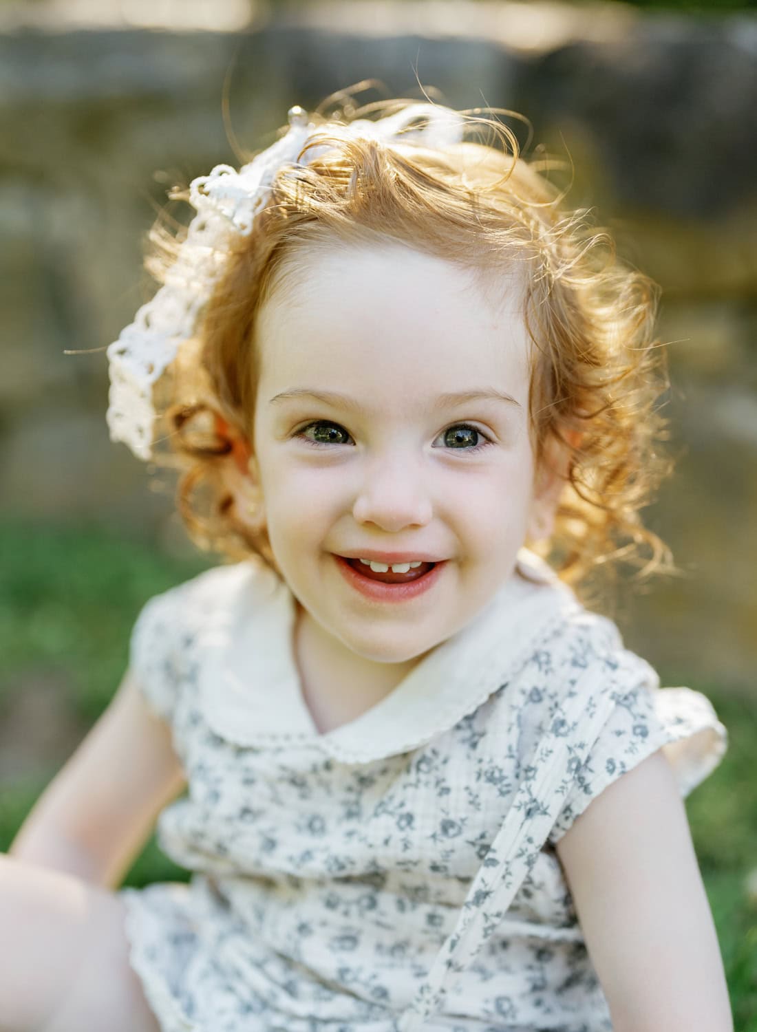 A young girl smiling in soft natural light during a family photography session in Yonkers.